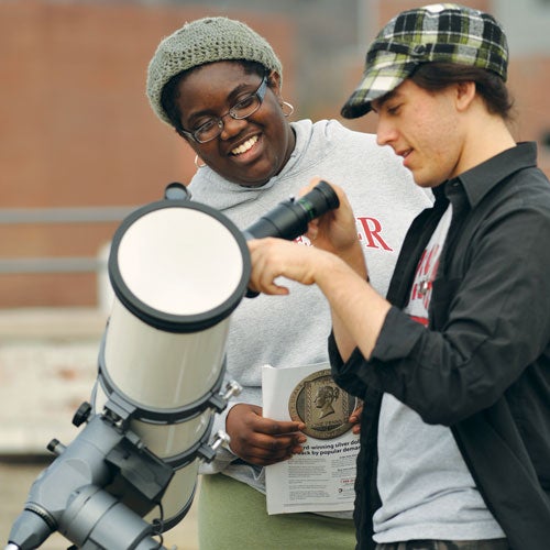 Two students working with a telescope