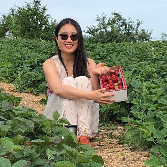 Student sits in a berry patch after picking strawberries