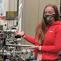 Sydney Neuman poses in front of machinery