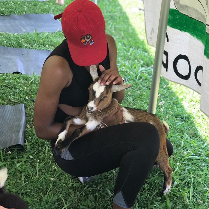 Student snuggles with a goat on her lap