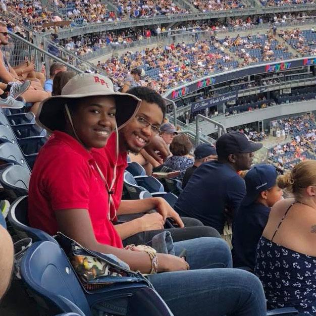 Two students watching a baseball game in NYC